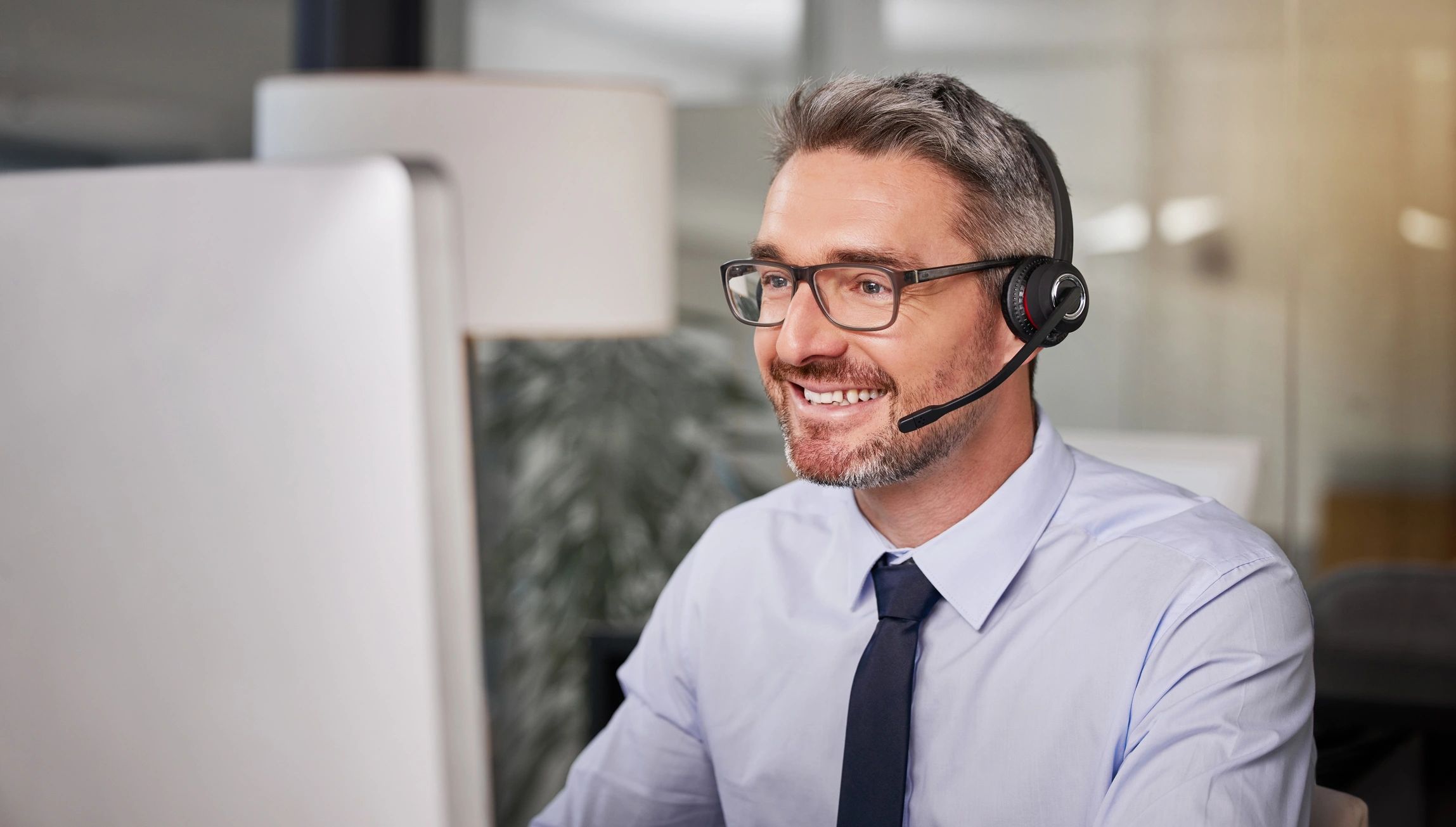Call center agent wearing a headset at a computer